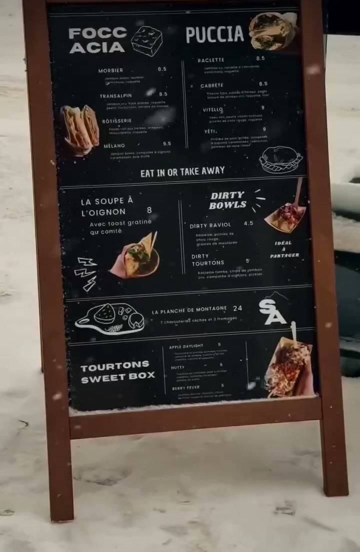Le tableau de la carte de Saveur Alpine, à Montgenèvre, posé dans la neige.